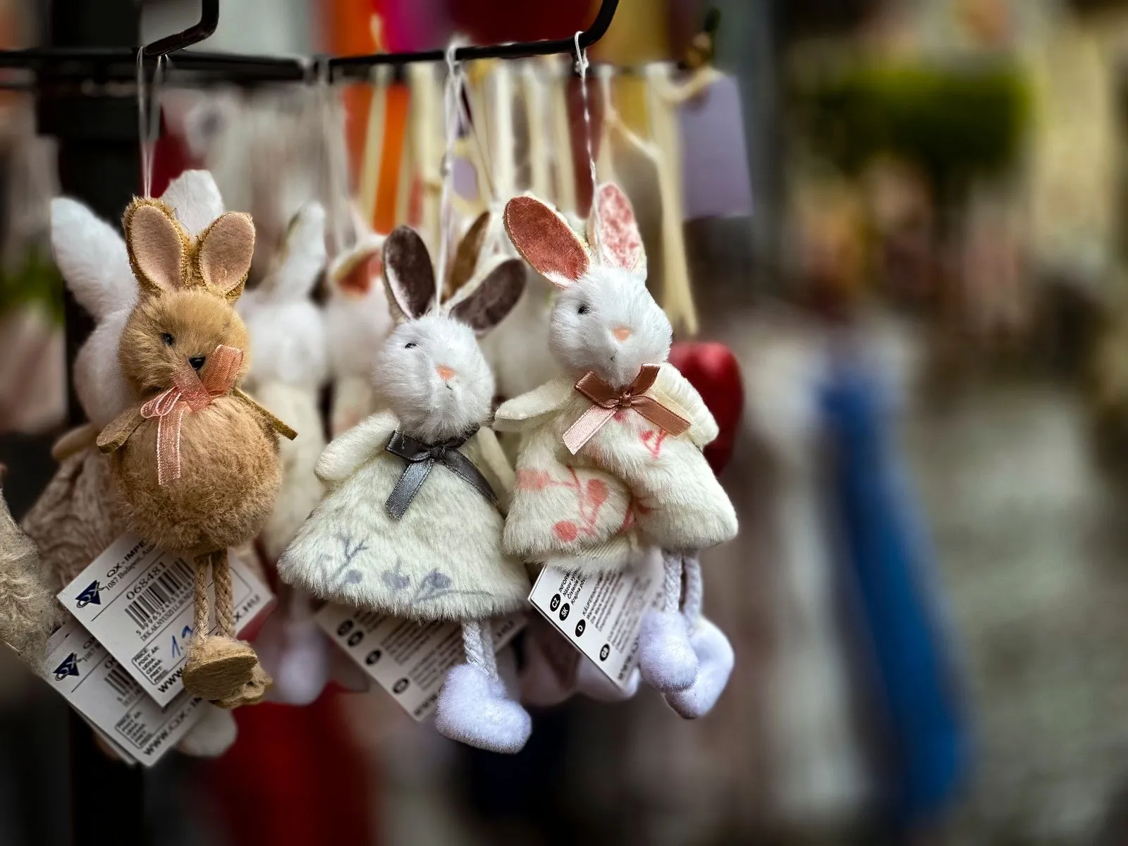 Adorable plush bunny keychains displayed in a colorful stall, perfect for gifts or merchandise.
